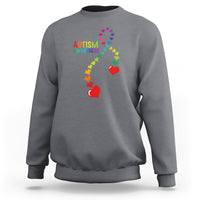 Dark heather gray sweatshirt with autism awareness puzzle heart and ribbon graphic.