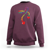 Maroon sweatshirt with autism awareness puzzle heart and ribbon graphic, crewneck.