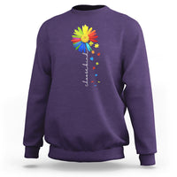 Purple crewneck sweatshirt with colorful sunflower and rainbow puzzle graphic on chest