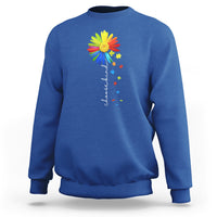 Blue crewneck sweatshirt with colorful sunflower and rainbow puzzle graphic on chest