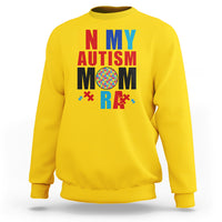 Yellow sweatshirt with colorful Autism Mom puzzle-piece graphic, crewneck long sleeves.