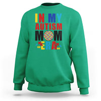Green sweatshirt with colorful Autism Mom puzzle-piece graphic, crewneck long sleeves.