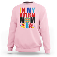 Pink sweatshirt with colorful Autism Mom puzzle-piece graphic, crewneck long sleeves.