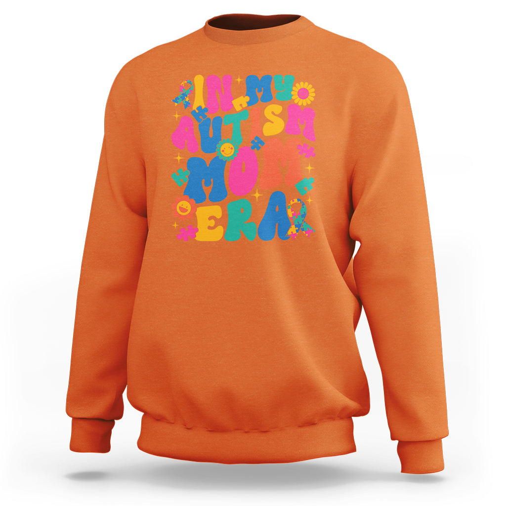Orange autism mom sweatshirt with colorful autism text and puzzle graphic