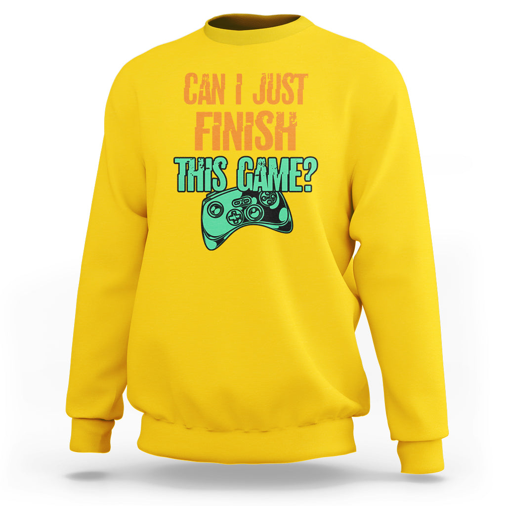 Daisy yellow crewneck sweatshirt with colorful “Can I just finish this game?” gamepad graphic.