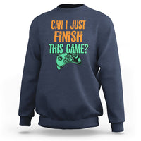 Navy crewneck sweatshirt with colorful “Can I just finish this game?” gamepad graphic.
