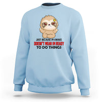 Light blue sweatshirt with cartoon sloth face and bold slogan graphic, crewneck pullover