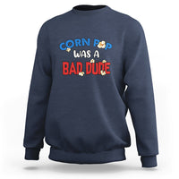 Navy sweatshirt with “Corn Pop was a bad dude” graphic printed on the chest
