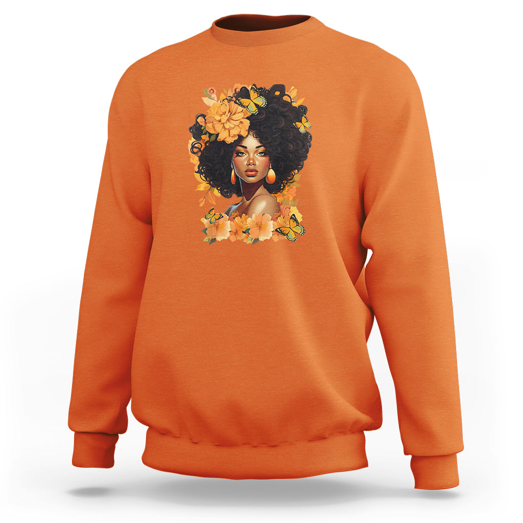 Orange crewneck sweatshirt with front portrait graphic and floral wreath