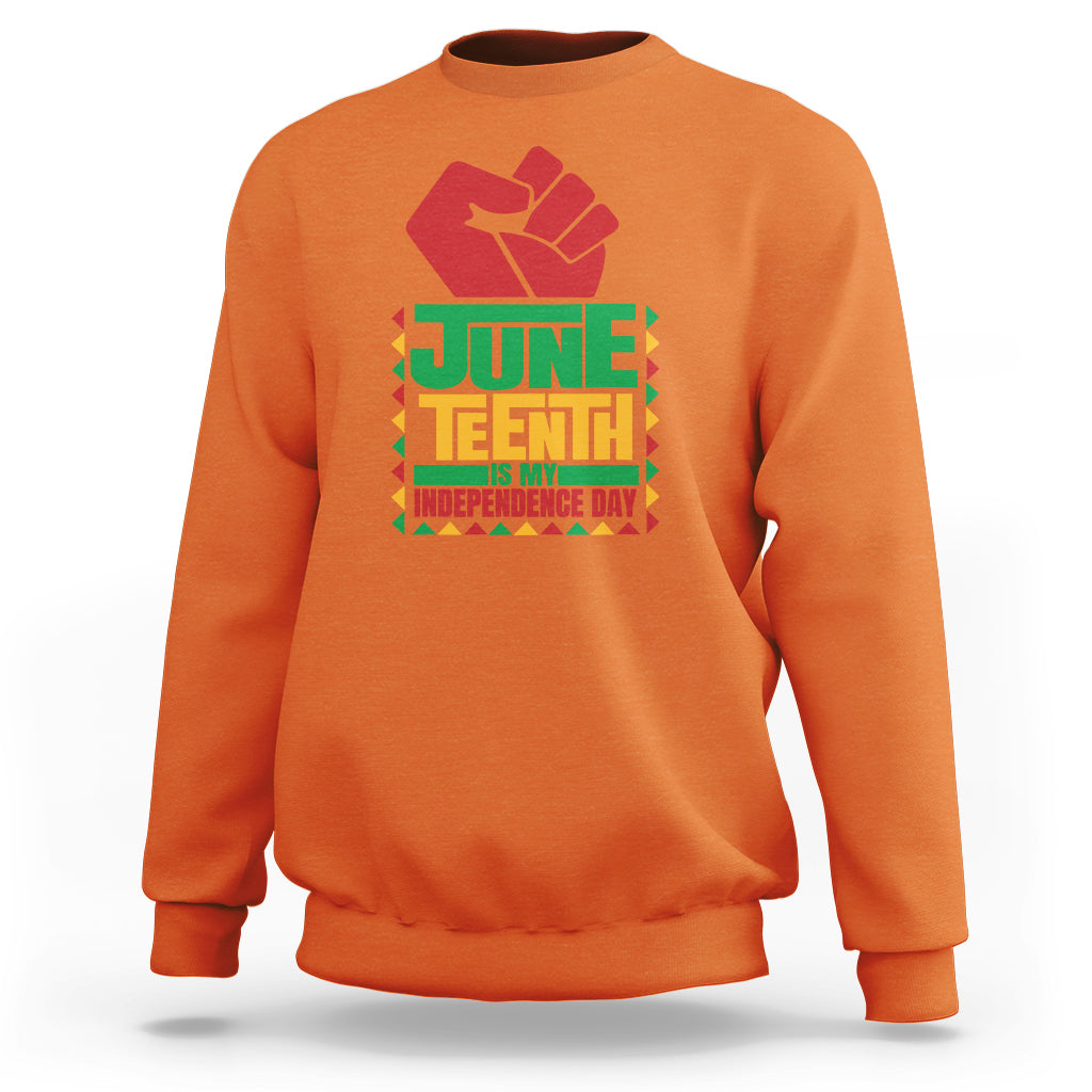 Orange crewneck sweatshirt with red hand graphic and Juneteenth independence text