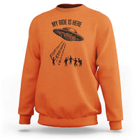 Orange crewneck sweatshirt with alien UFO graphic and abduction silhouettes