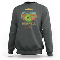 Charcoal gray crewneck sweatshirt with “Roswell 1947” alien abduction graphic on front