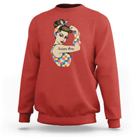 Red crewneck sweatshirt with autism-themed face graphic on chest.