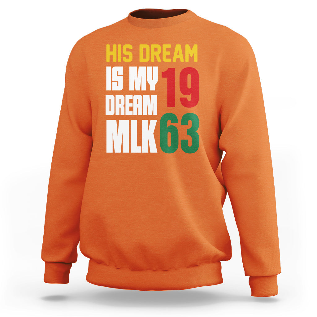 Orange crewneck sweatshirt with colorful text graphic: "HIS DREAM IS MY DREAM 19 MLK63"