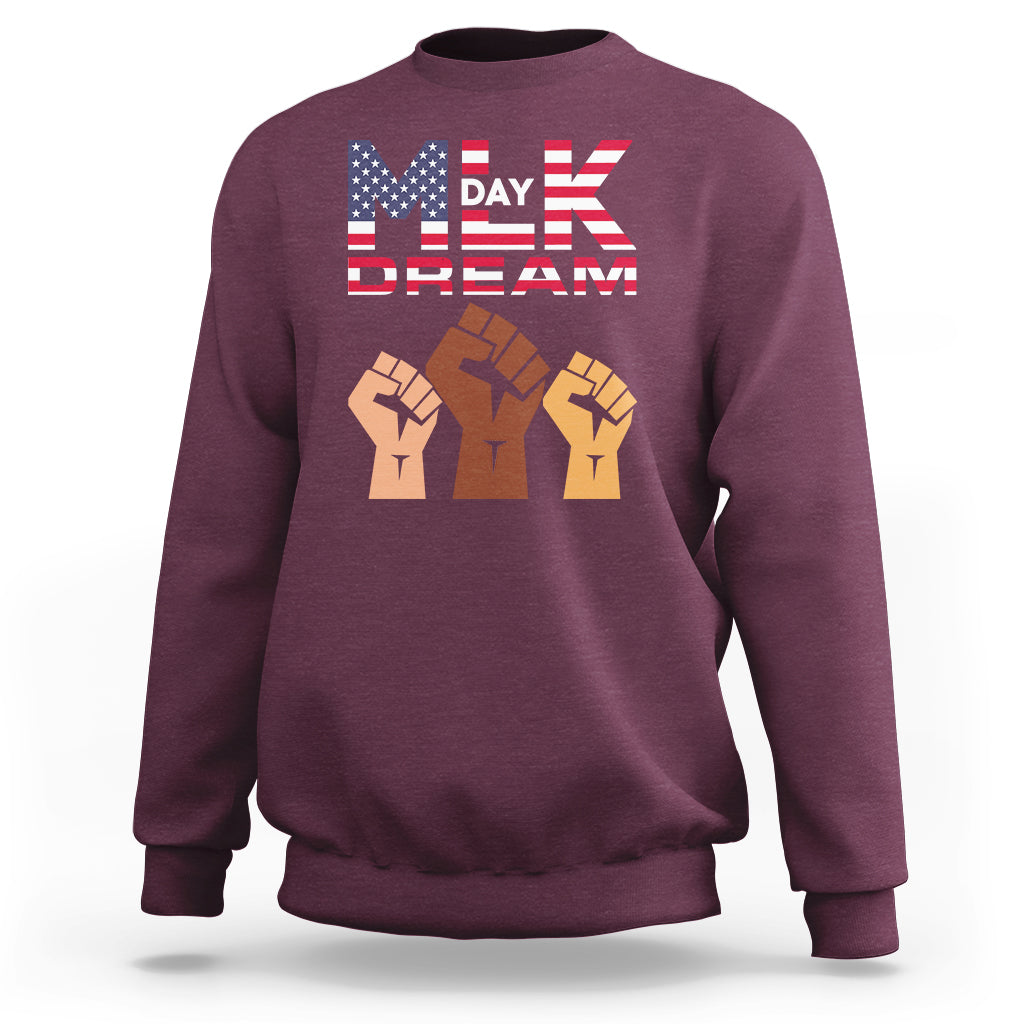 Maroon crewneck sweatshirt with “MLK Day Dream” graphic and raised-fist design on chest