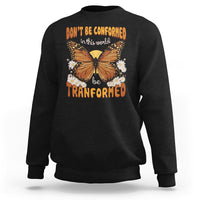 Black crewneck sweatshirt with front butterfly graphic and “be transformed” inspirational text