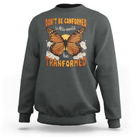 Dark gray crewneck sweatshirt with front butterfly graphic and “be transformed” text