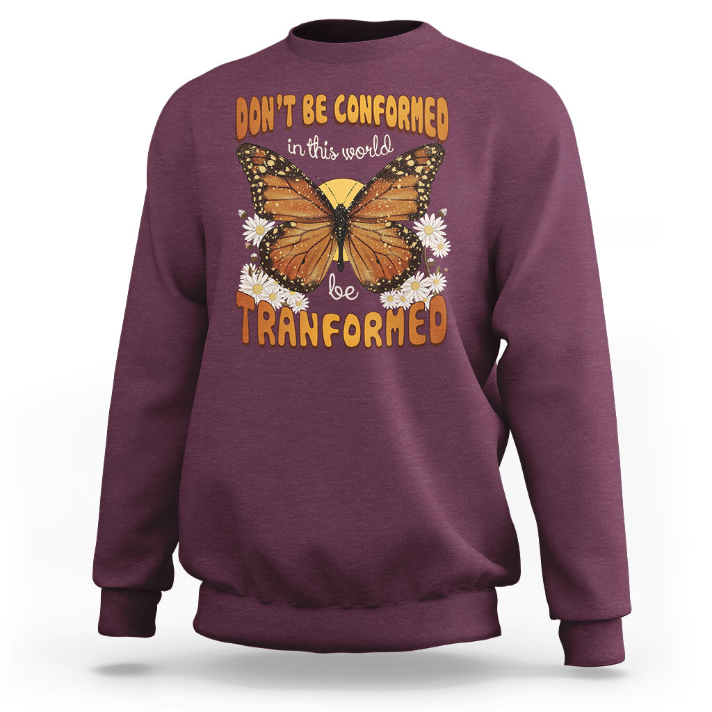 Burgundy crewneck sweatshirt with front butterfly graphic and “be transformed” text