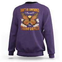 Purple crewneck sweatshirt with front butterfly graphic and “be transformed” inspirational text