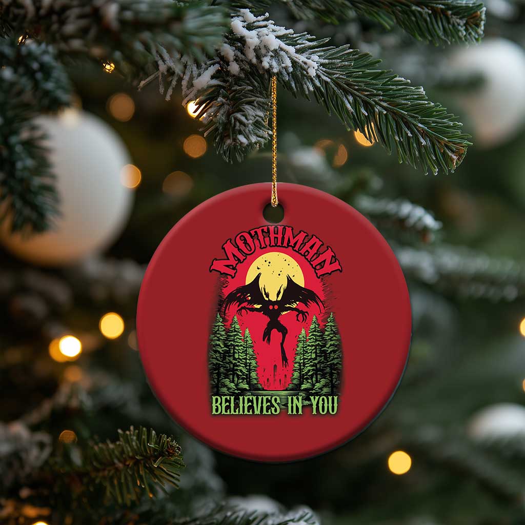 Red round Mothman Christmas ornament with “Believes in You” hanging on a tree