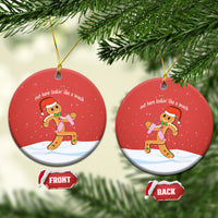 Red round ceramic ornament with gingerbread runner graphic and gold hanging loop.