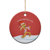 Red round ceramic ornament on gold string, showing gingerbread runner graphic.