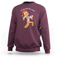 Maroon crewneck sweatshirt with colorful gingerbread man graphic on the chest