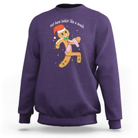 Purple crewneck sweatshirt with colorful gingerbread man graphic on the chest