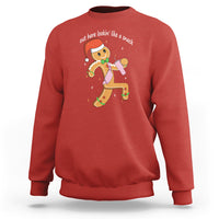Red crewneck sweatshirt with colorful gingerbread man graphic on the chest