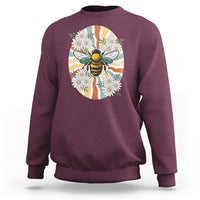 Maroon crewneck sweatshirt with bee-and-daisy graphic on front