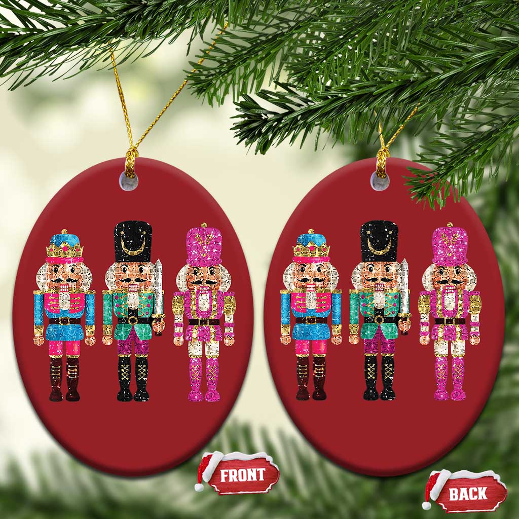 Two red oval nutcracker sequin ornaments with three characters each, gold hanging loops