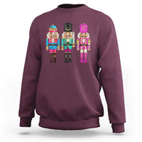 Maroon crewneck sweatshirt with colorful sequin nutcracker graphic on the chest