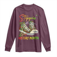 Maroon long-sleeve T-shirt with sneakers and “Steppin’ Black History Month” graphic
