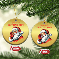 Two gold round Santa Christmas ornaments with hanging strings and “You ain’t getting…” text