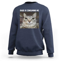 Navy crewneck sweatshirt with cat graphic and 'RAGE IS CONSUMING ME' text on chest.