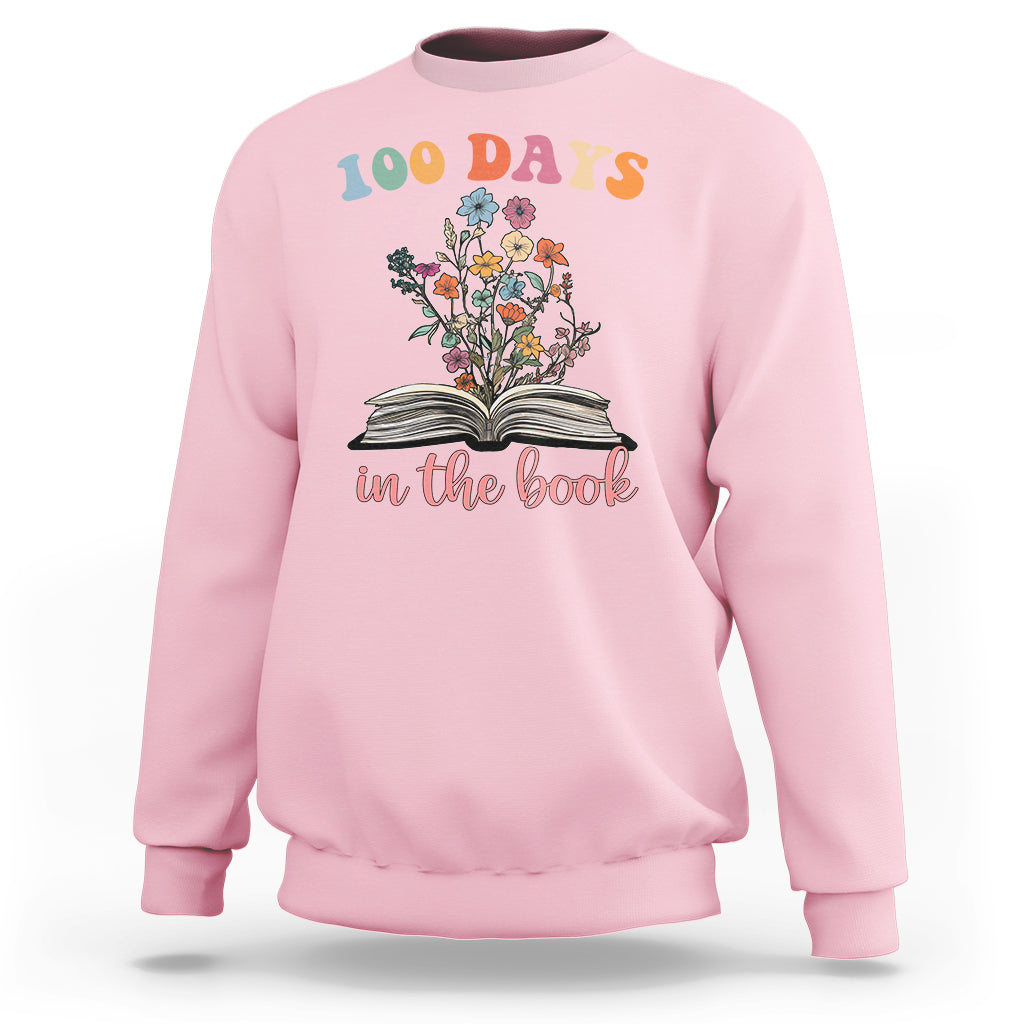 Light pink crewneck sweatshirt with “100 Days” floral open-book “in the book” graphic
