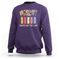 Purple crewneck sweatshirt with flower test-tube graphic and 'SAVED BY THE LAB' lettering