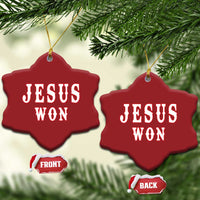 Red snowflake-shaped ornament with 'JESUS WON' text, hung with gold cords.