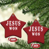 Red star-shaped ornament with 'JESUS WON' text, hung with gold cord.