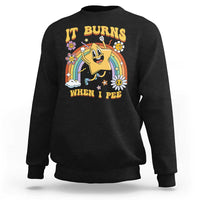 Black crewneck sweatshirt with colorful “IT BURNS WHEN I PEE” graphic on front