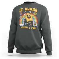 Dark heather gray crewneck sweatshirt with colorful “IT BURNS WHEN I PEE” graphic on front
