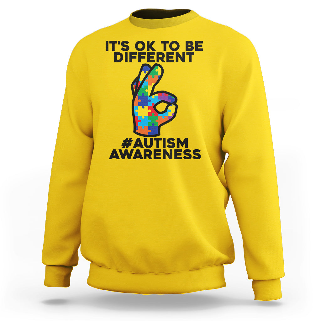 Yellow crewneck sweatshirt with “It’s OK to be different” and “#Autism Awareness” text