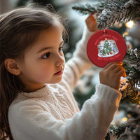 Red round Christmas ornament hanging on evergreen branches