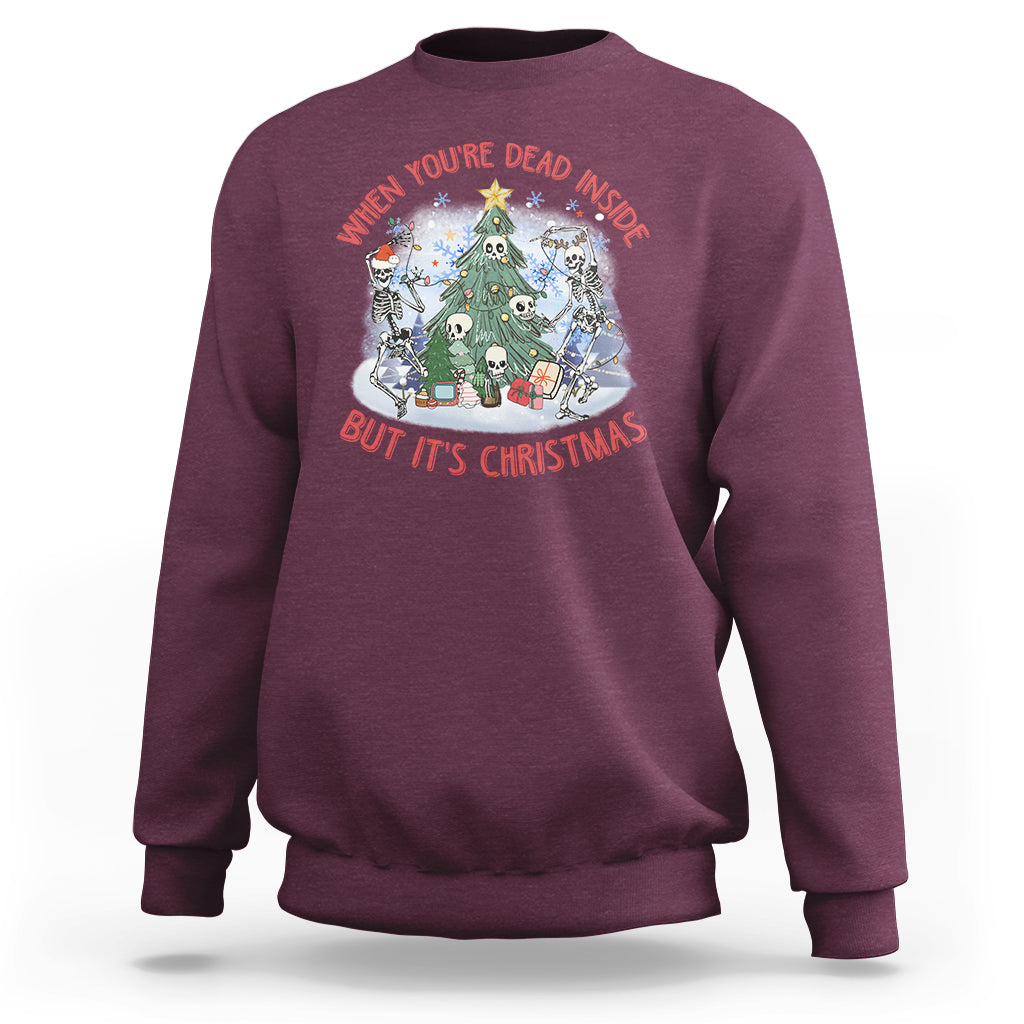 Maroon crewneck sweatshirt with Christmas graphic: skeletons around a tree, red/white text