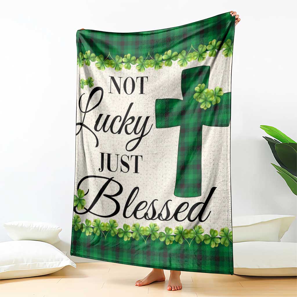 Green buffalo plaid shamrock throw blanket with cross motif, draped on sofa