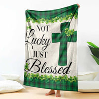 Green buffalo plaid shamrock throw blanket with cross motif, draped on sofa