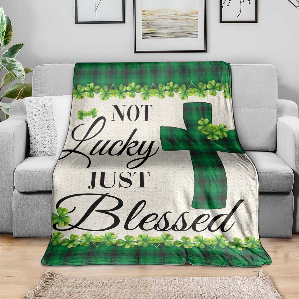Green buffalo plaid shamrock throw blanket with cross motif, spread over couch