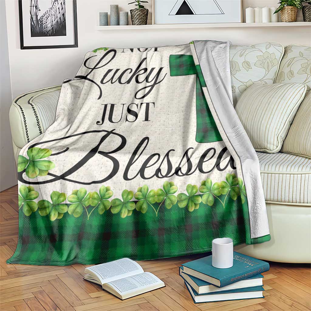 Green buffalo plaid shamrock throw blanket with cross motif, draped over bed