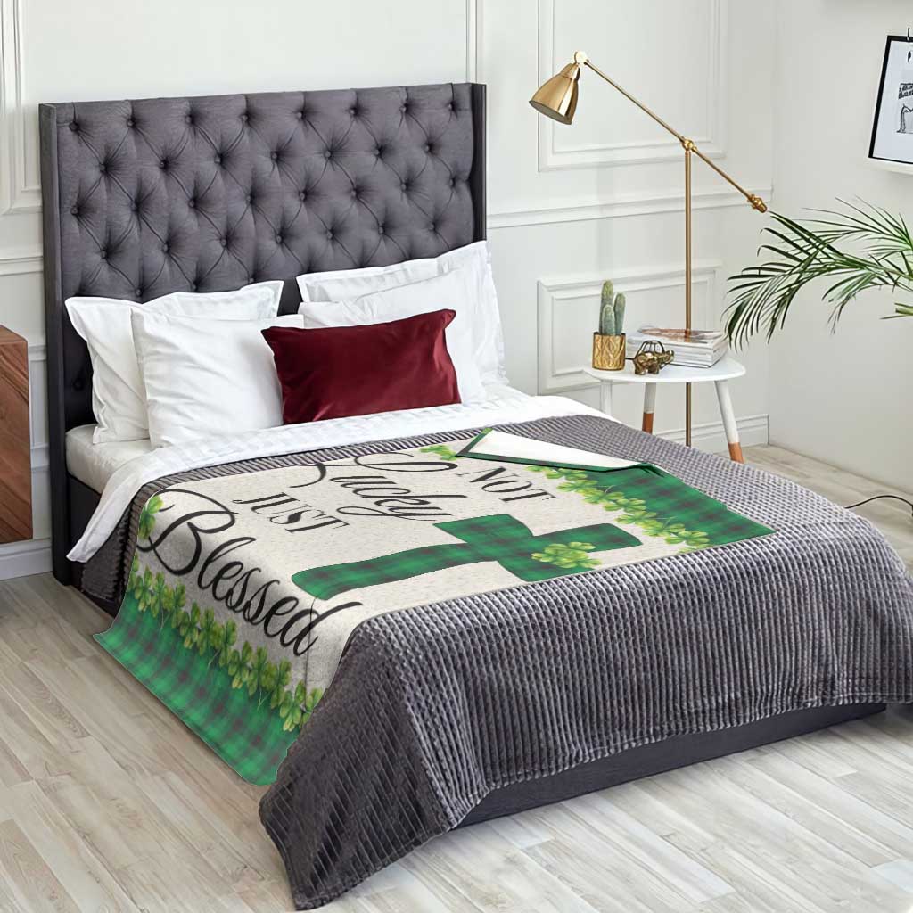 Green buffalo plaid shamrock throw blanket with cross motif on bed surface