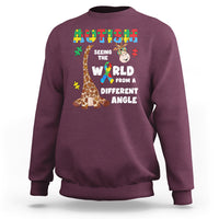 Maroon crewneck sweatshirt with giraffe puzzle graphic and autism-style slogan on front